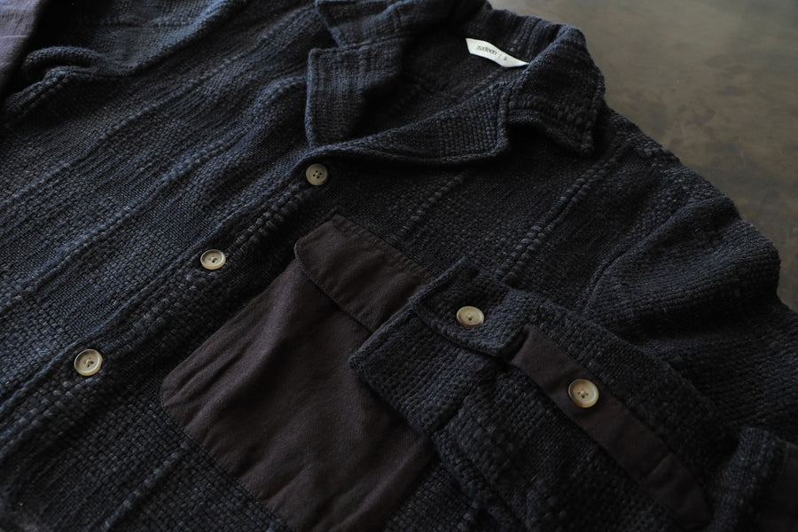 An up close look at the irregular texture on the black hand loomed shirt.
