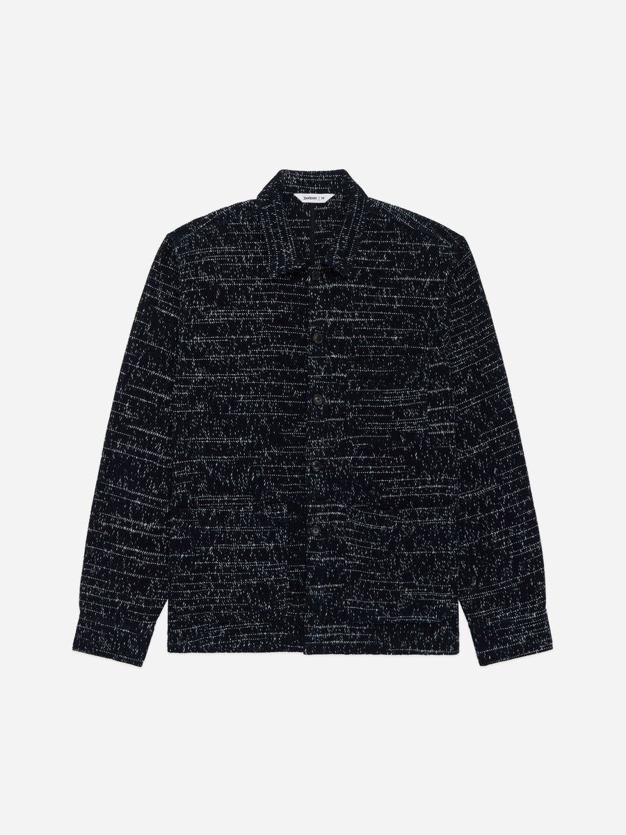 A dark navy blue textured jacket with a subtle horizontal woven pattern, featuring a pointed collar and long sleeves, shown against a plain light gray background.