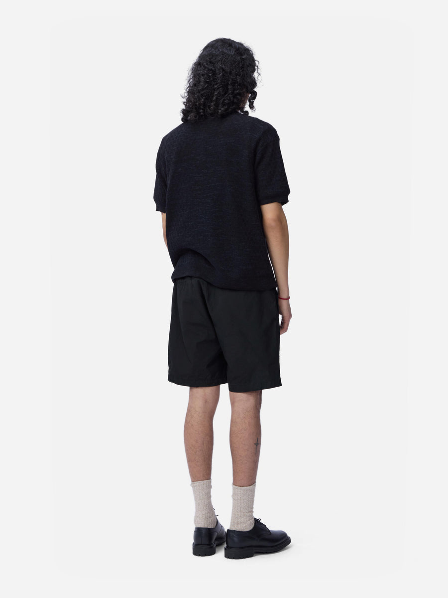 Person wearing a black t-shirt and shorts on a white background