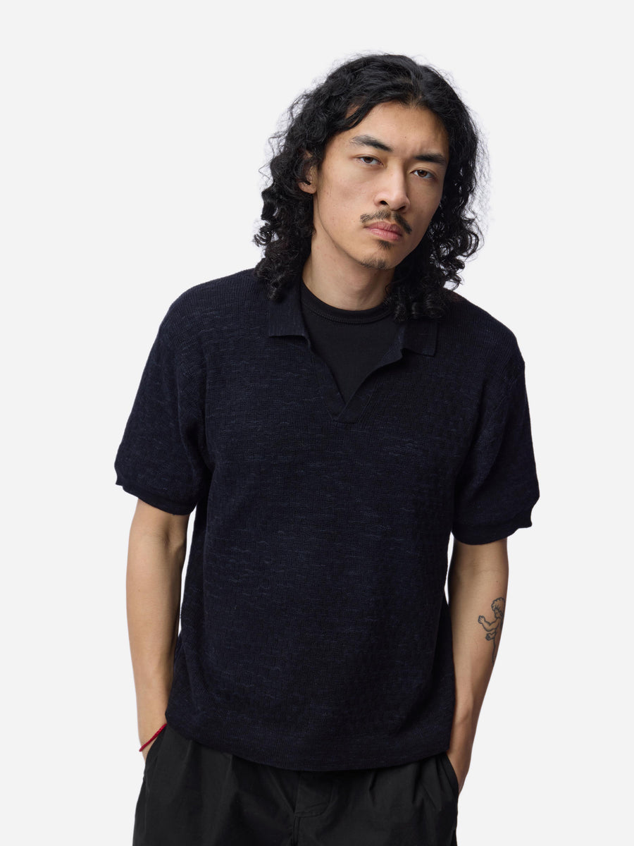Man wearing a black polo shirt against a white background