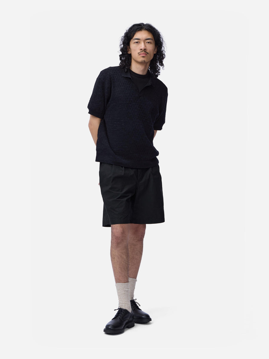Person wearing a black outfit with shorts on a white background