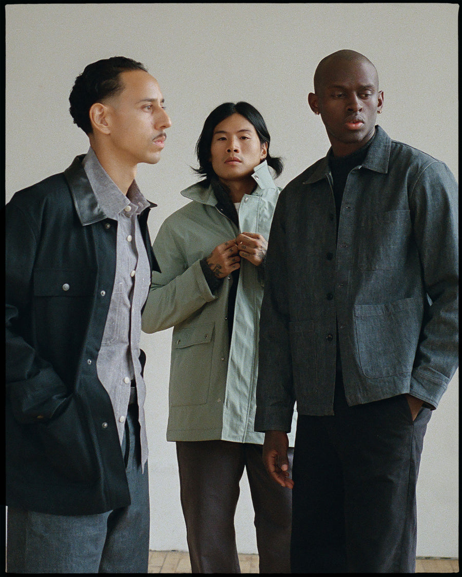 Three guys wearing dark earth toned clothing