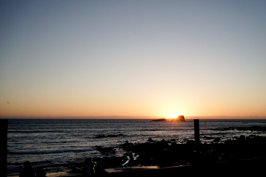 The sun dips across the horizon over the Pacific Ocean.