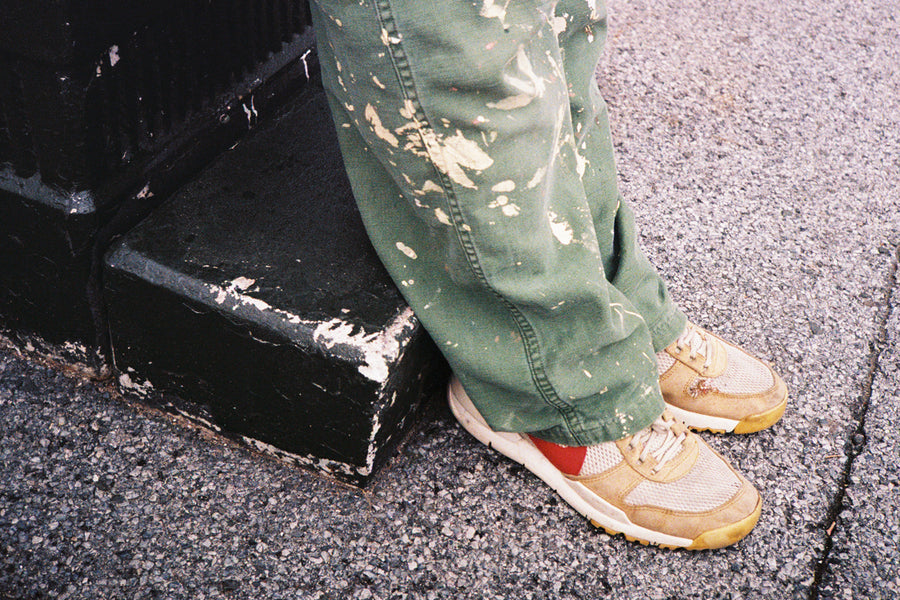 Worn-in sneakers on an asphalt playground.