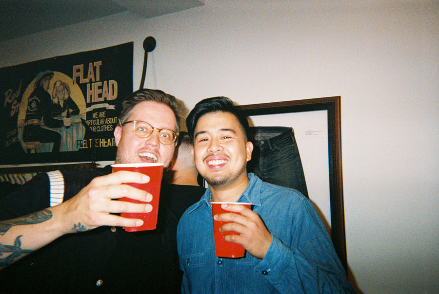 Two drunk friends laugh and drink together.